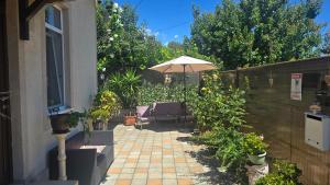 a patio with an umbrella and chairs and plants at Casa Cristal in Eforie Sud +24 photos