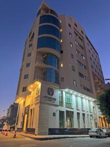 a tall building with a car parked in front of it at Attawfeek Hotel in Tripoli
