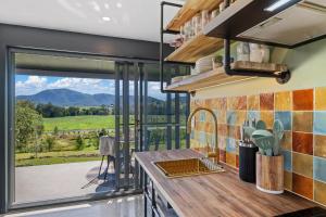 a kitchen with a large window with a view at Dundalli Lodge in Conondale