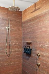 a shower in a bathroom with a wooden wall at Dundalli Lodge in Conondale