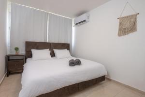 a bedroom with a bed with two slippers on it at הדירה של אייזיק - דירה מהממת במצפה רמון עם נוף מדהים in Mitzpe Ramon