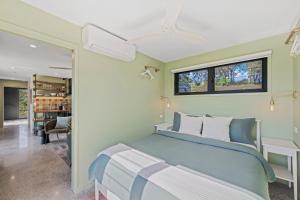 a bedroom with a blue bed and a window at Dundalli Lodge in Conondale