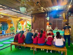 a group of people sitting on a bench in a room at Family Room in Tam Kỳ
