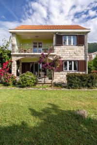 a house with a balcony and a yard at Boka Garden in Bijela
