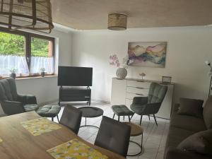 a living room with a table and chairs and a television at Apartment Grenzland in Herzogenrath