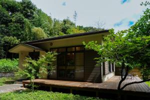 a small house with a wooden deck in front at Beppu TOJIHAUS 002 Hilltop Sea View 8min walk to Hells of Beppu in Beppu