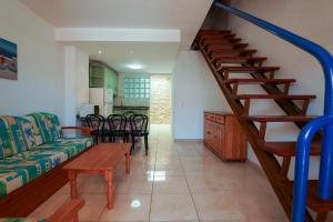 a living room with a staircase with a couch and a table at Apartamentos Panamá in Puerto Rico de Gran Canaria