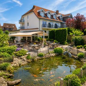 a hotel with a koi pond in front of a building at Kurhotel Grüttner mit eigenem Sole Thermal Schwimmbad 32 Grad und Saunalandschaft in Erwitte
