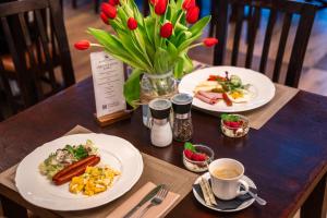 a table with two plates of food and a vase of flowers at Końska Dolina in Krynica Zdrój