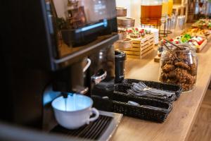 a counter with a coffee maker with a cup and food at Końska Dolina in Krynica Zdrój +73 photos