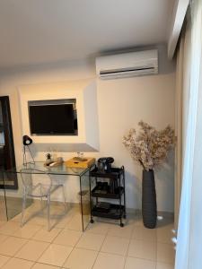 a dining room with a glass table and a television at Ktima Papaoikonomou in Potos