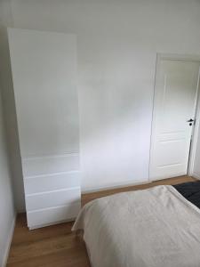 a bedroom with a bed and a white wall at Wonderfully unique accommodation in Bålsta