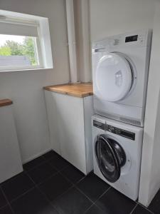a washer and dryer in a small room with a window at Wonderfully unique accommodation in Bålsta +2 photos