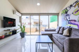 a living room with a couch and a table at Rooftop one BDR with Terrace in Al Bawsharīyah