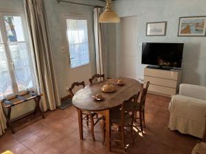 a living room with a wooden table and a television at Blanc Marine in Noirmoutier-en-l'lle