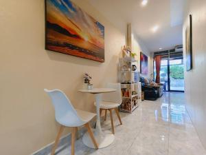 a living room with a table and chairs and a painting at Mays Hostel in Hua Hin