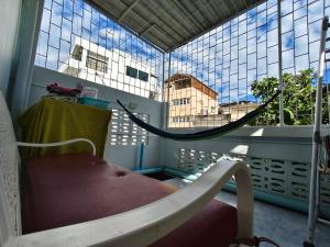 a balcony with a hammock in a room with a window at Mays Hostel in Hua Hin