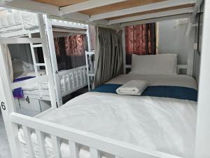 a bedroom with two bunk beds and a crib at Mays Hostel in Hua Hin