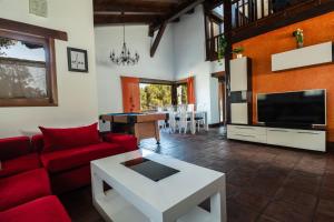 a living room with a red couch and a tv at VUT Carrascosos, oasis familiar by Cabana Rentals in El Espinar