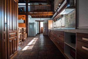 a kitchen with wooden cabinets and a tile floor at VUT Carrascosos, oasis familiar by Cabana Rentals in El Espinar