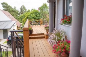 a wooden deck with tables and flowers on a house at Biesy2 in Wetlina