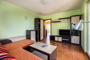 a living room with a couch and a tv at Boka Garden in Bijela