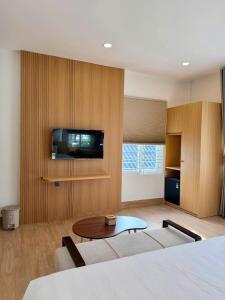 a room with a bed and a tv on a wall at Hue Glow Homestay in Thôn Lại Thê