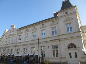 ein großes weißes Gebäude mit einem Uhrturm in der Unterkunft Pension Domke in Ahlbeck