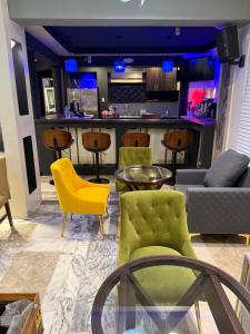 a living room with a couch and chairs and a bar at Richcastle Hotel in Freetown
