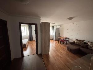 a living room with a couch and a clock on the wall at Mio Apartments Silver in Cluj-Napoca
