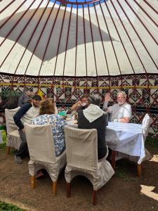 a group of people sitting at a table in a tent at Asiya in Karakol