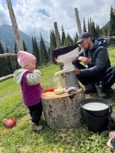 a little girl standing next to a blender next to a man at Asiya in Karakol