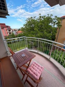 a balcony with a wooden table and a bench at Guest House Karavida in Sinemorets