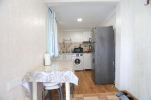 a small kitchen with a table and a refrigerator at BANI tsikhisdziri in Ts'ikhisdziri
