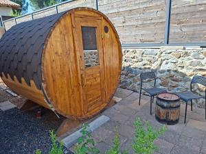 a large wooden barrel sitting next to two chairs at El Room Zimmer in El-Rom