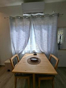 a wooden table with two chairs in front of a window at El Room Zimmer in El-Rom