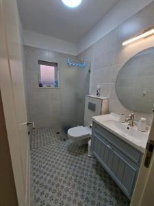 a bathroom with a toilet and a sink and a mirror at El Room Zimmer in El-Rom