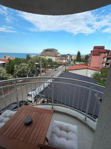 a balcony with a table and chairs and a street at Guest House Karavida in Sinemorets