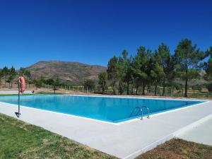 a swimming pool in a field with mountains in the background at Casa do Sobrado-Gralhas-Montalegre in Gralhas