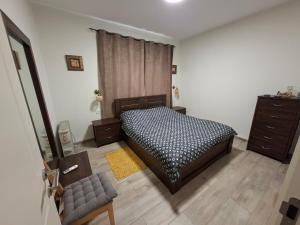 a bedroom with a bed and a dresser at El Room Zimmer in El-Rom