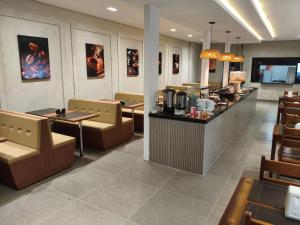 a restaurant with a counter and tables and chairs at Hotel Kanaan in Pimenta Bueno +22 photos
