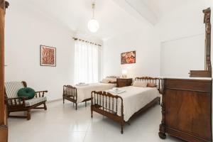 a white room with two beds and a couch at "Fiordolce" a due passi dal mare in Vado Ligure