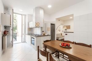 a kitchen and dining room with a wooden table at "Fiordolce" a due passi dal mare in Vado Ligure