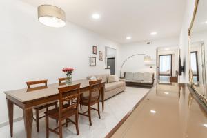 a dining room and living room with a table and chairs at "Fiordolce" a due passi dal mare in Vado Ligure