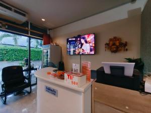 a living room with a tv on the wall at Mays Hostel in Hua Hin