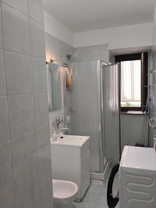 a white bathroom with a sink and a toilet at Casa Vacanze Daniele in Pontecagnano +37 photos