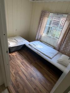 two beds in a small room with a window at Detached cozy house in Lom