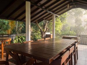 a wooden table on a deck with a tree at Top Mountain Resort in Diyatalawa