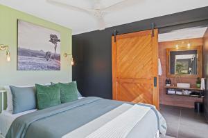a bedroom with a large bed with a wooden door at Jinibara Cottage in Conondale
