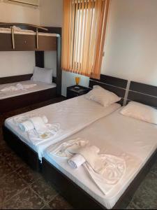 two beds in a room with towels on them at Хотел Свети Димитър in Sozopol